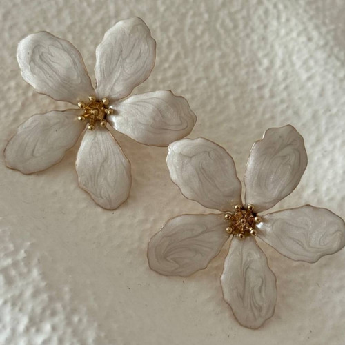 نمای نزدیک ازگوشواره میخی طرح گل پنج پر کرم و طلایی