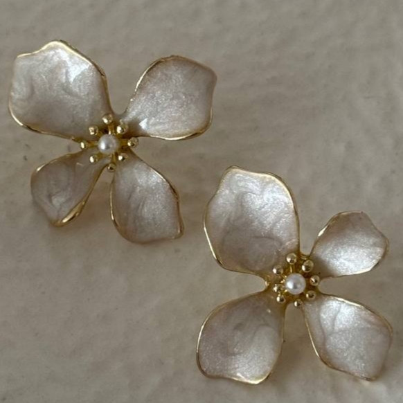 نمای نزدیک گوشواره میخی طرح گل چهارپر صدفی با تکمروارید در مرکز و لبه طلایی.